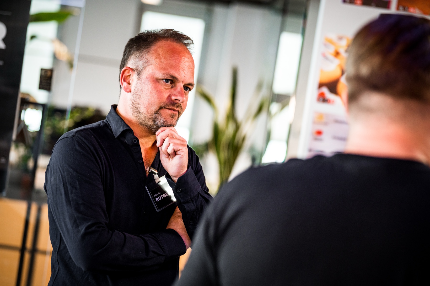 Twee mensen in gesprek, een luistert kritisch mee