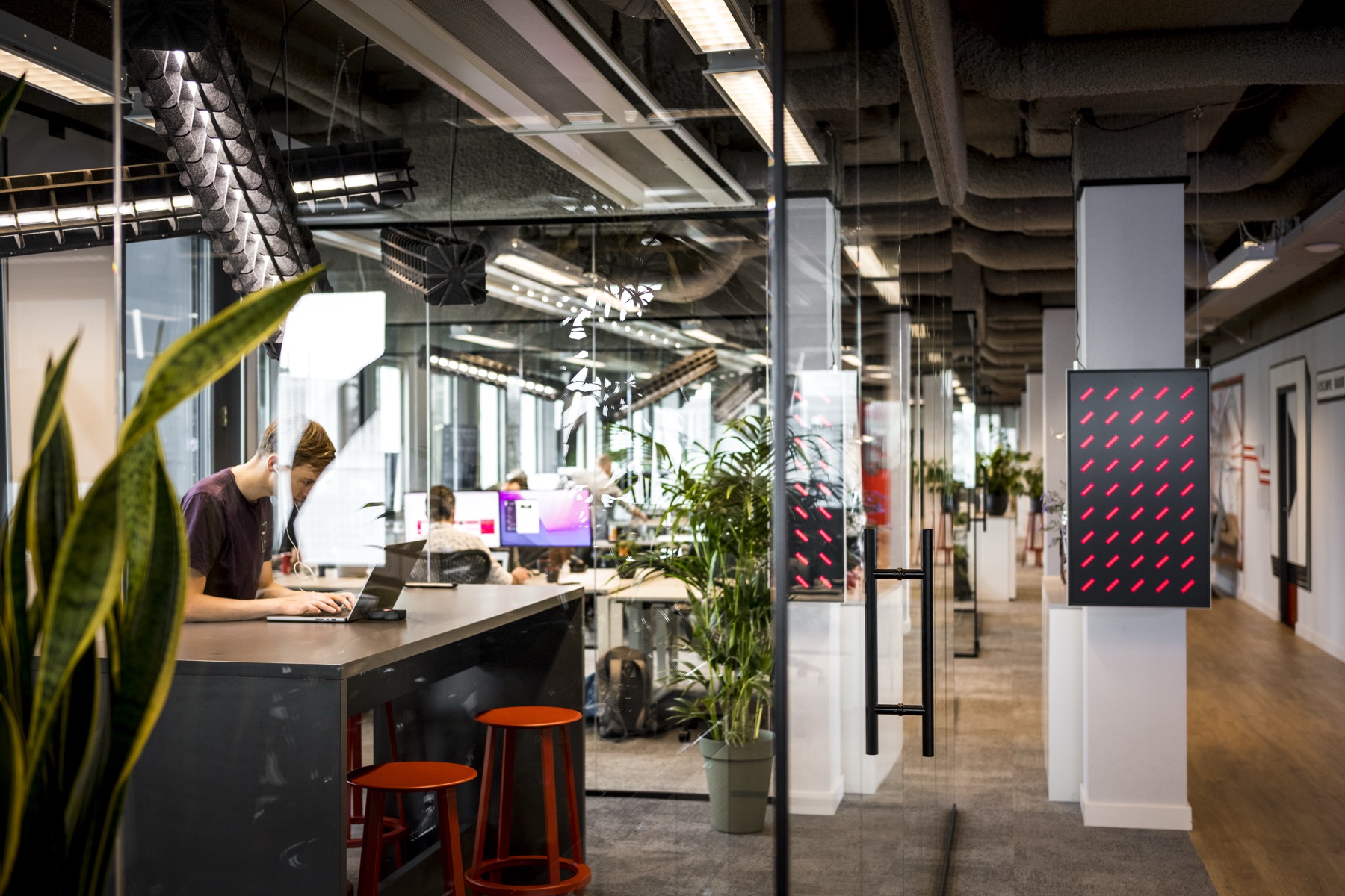 Kantoorgang met glazen wanden en werkplekken