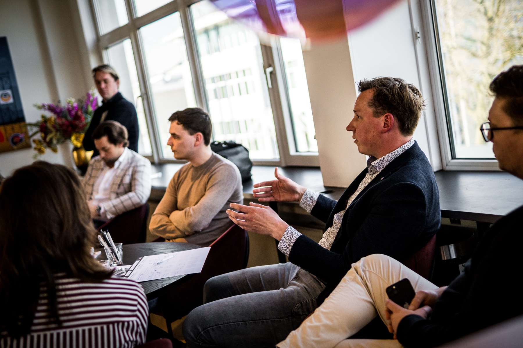 Adviseur beantwoordt vragen van een groep aan tafel
