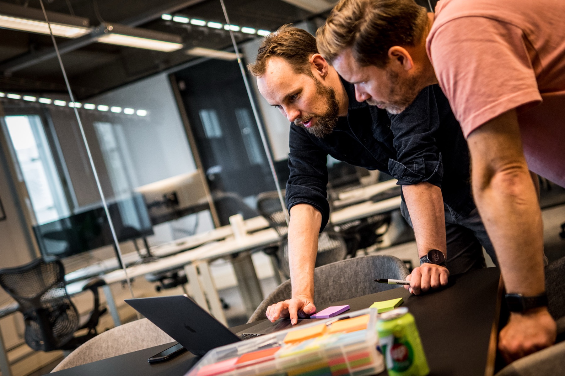 Twee collegas buigen samen over een laptop