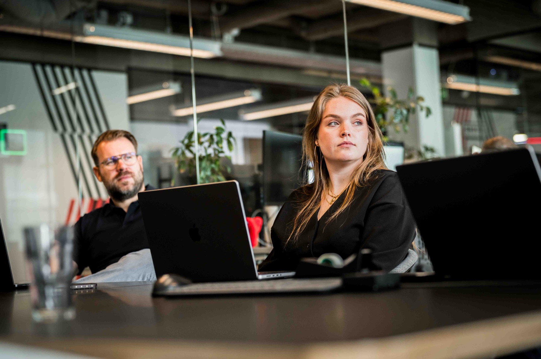 Twee collegas werken naast elkaar aan de werktafel