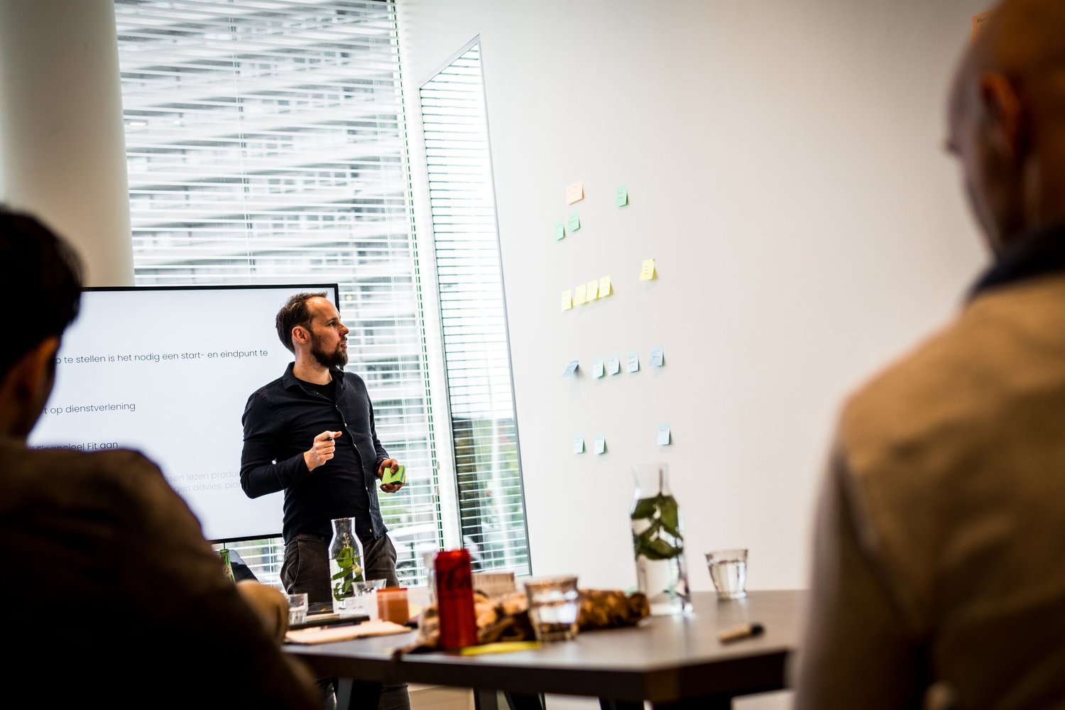 Presentatie tijdens een workshop met post-its op de muur